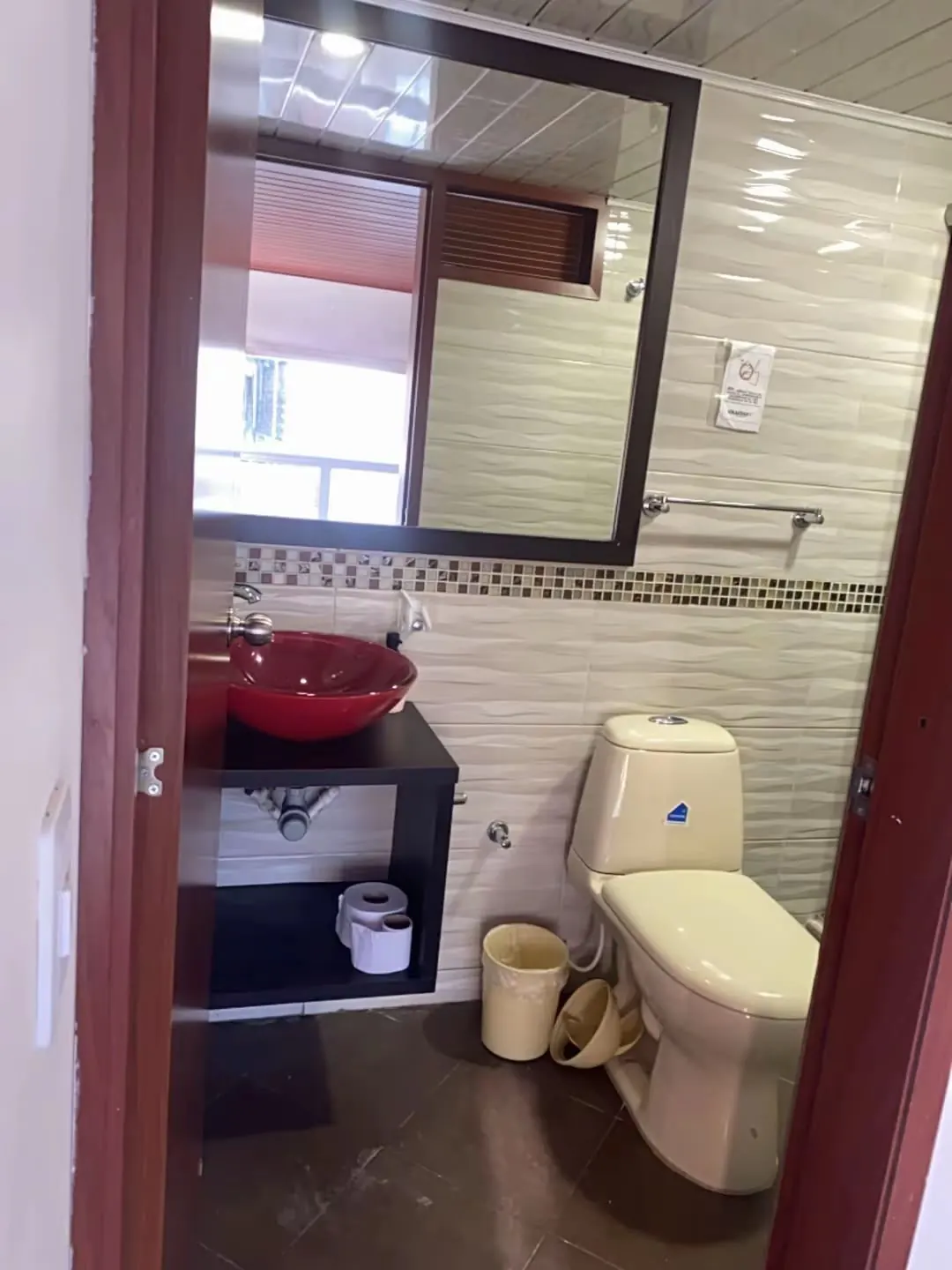 Baño con lavamanos y espejo en Hospedaje Kiwi