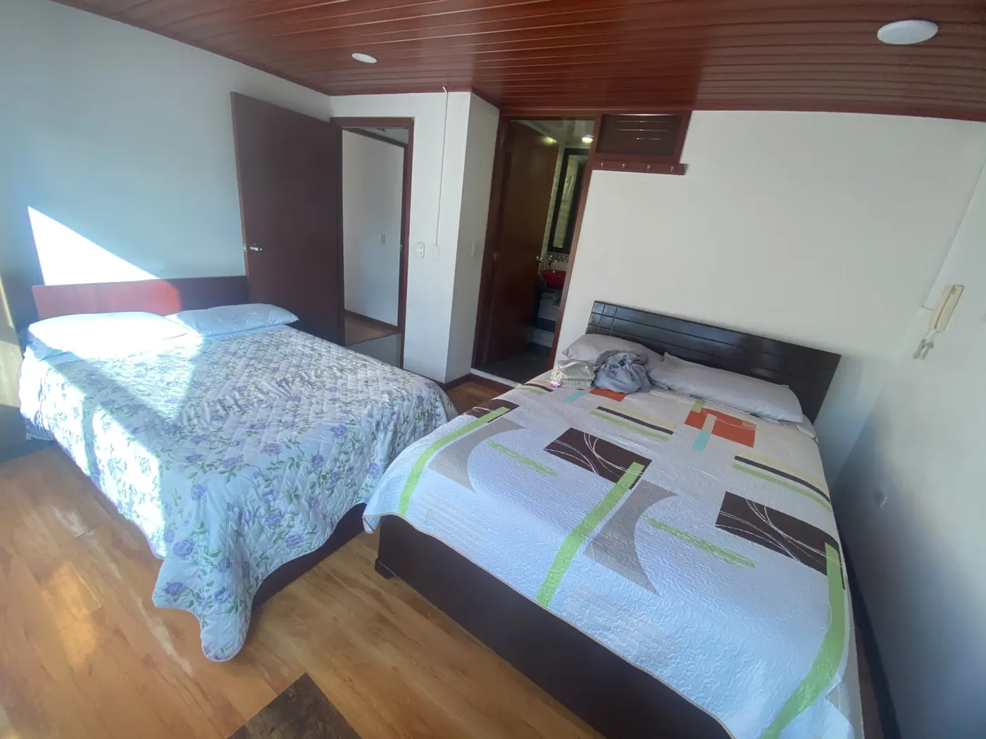 Habitación doble con dos camas sencillas y ventana en Hospedaje Kiwi