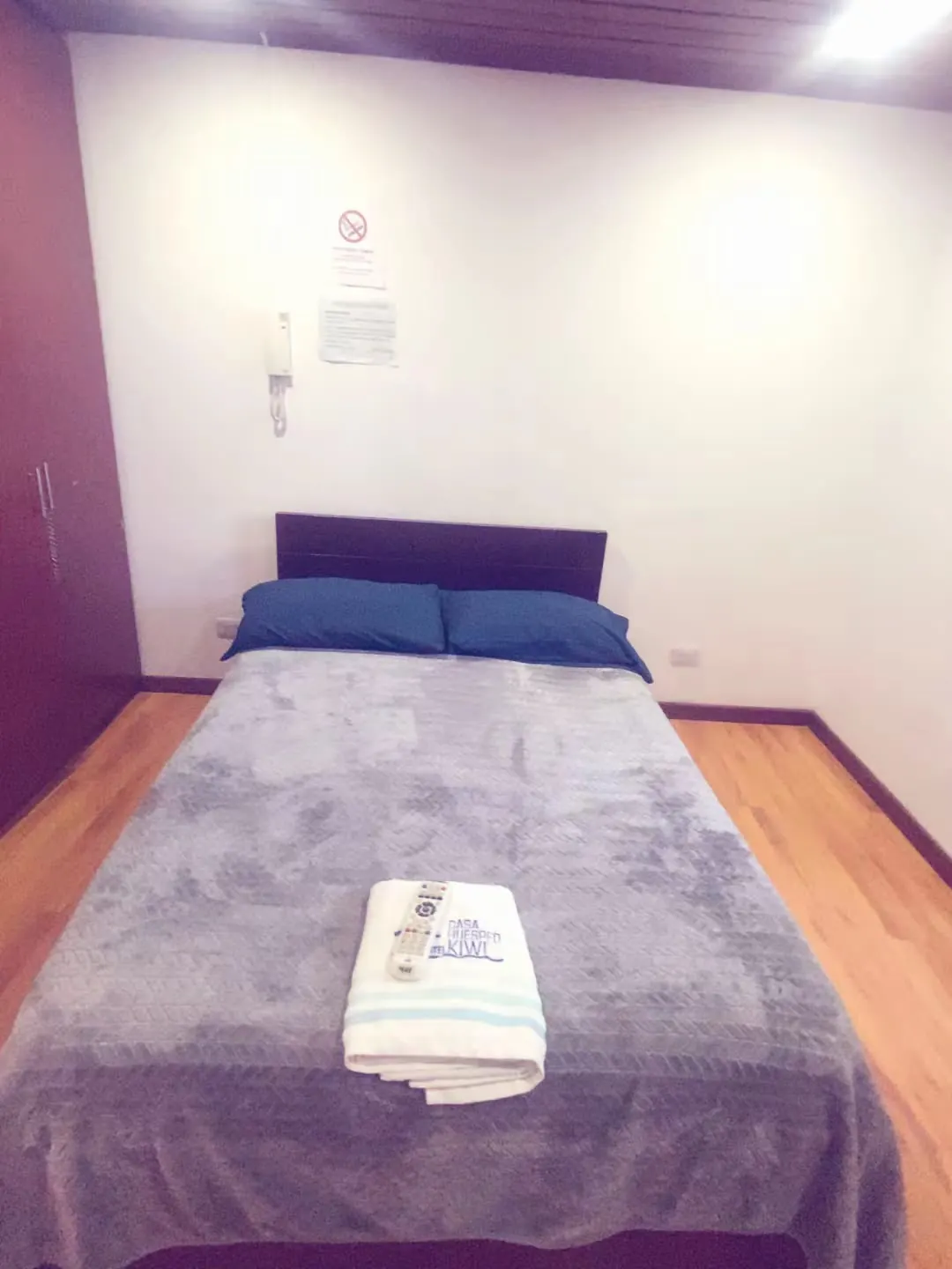 Cama matrimonial con toallas limpias sobre la cama en una habitación de Hospedaje Kiwi